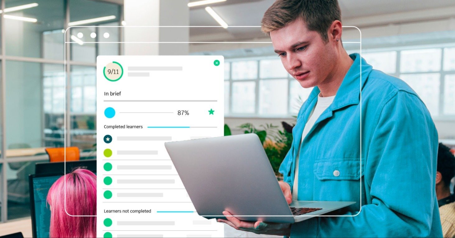 A male student focused on a laptop screen that displays the final stage of a vocational skills training program.